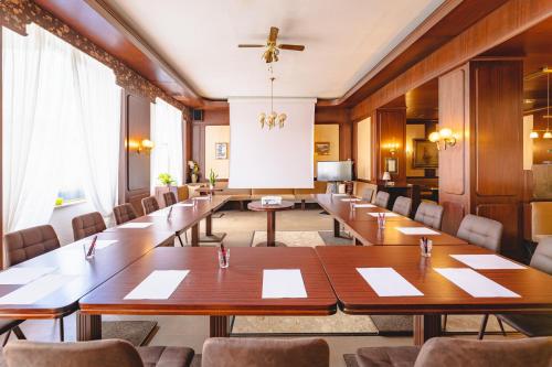 a conference room with long tables and chairs at Hotel Zentral in Wiener Neustadt