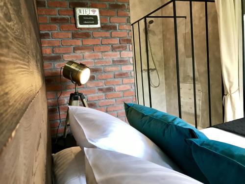 a room with two pillows and a brick wall at LES ÉCRINS - B&B with jacuzzi in Orbey
