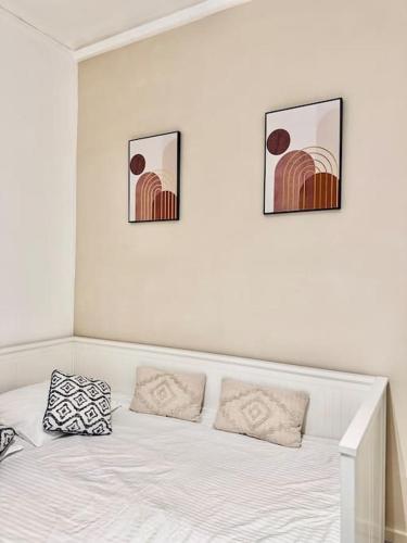 une chambre avec un lit avec deux tableaux au mur dans l'établissement Studio cosy à Porte de Versailles, à Paris