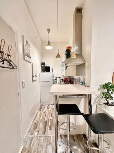 une petite cuisine avec un comptoir et deux tabourets dans l'établissement Studio cosy à Porte de Versailles, à Paris