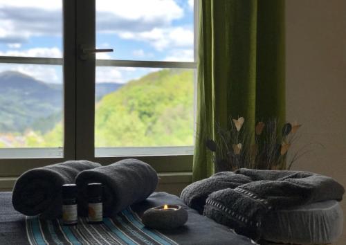 a room with a window and a couch with a candle at LES ÉCRINS - B&B with jacuzzi in Orbey