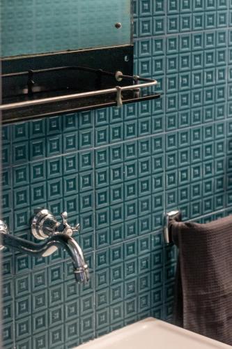 a bathroom with a sink and a blue tiled wall at Mina Suites in Cervia