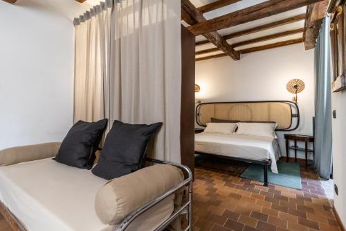 a bedroom with two beds in a room with wooden ceilings at Mina Suites in Cervia