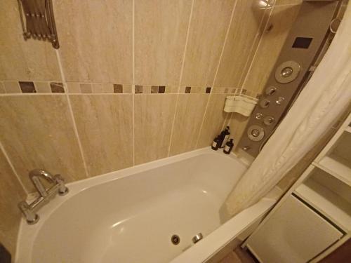 a white bath tub in a bathroom with a shower at The Rushdon in Grays Thurrock