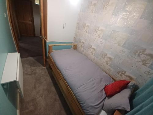 a small bed in a room with a wall at The Rushdon in Grays Thurrock