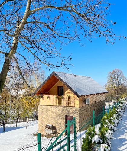 a small house in the snow with a fence at Vikend kuca pod lipom in Rudnik Kačerski