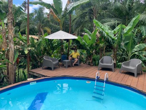 a woman sitting in a chair next to a pool at Los Bananos - Big Wood Cabin in Puerto Iguazú