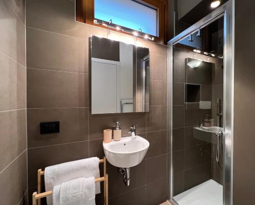 a bathroom with a sink and a mirror and a shower at Holiday Homes in Viadanica Colognola