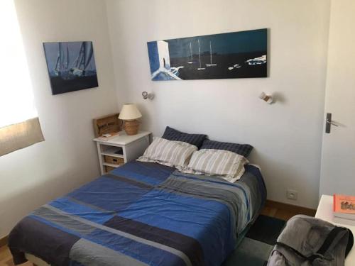 une chambre avec un lit avec une couverture bleue dans l'établissement Appartement vue mer Pointe Rouge, à Marseille