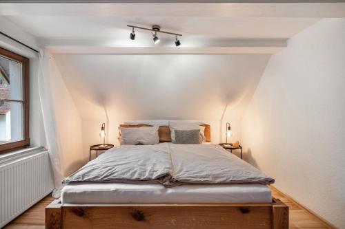 a bed in a room with two lamps and a window at Schwarzwaldmomente in Hornberg