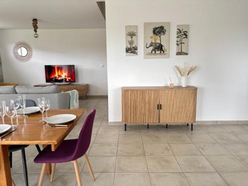 un salon avec une table et un canapé dans l'établissement Les Voiles, maison bien équipée 10 p 2 sdb, 2 WC, spacieuse lumineuse avec jardin clos, garage, terrasse, parking privatif, à 950 m de la plage d'Asnelles et tous commerces, près de Bayeux et Arromanches, à Asnelles