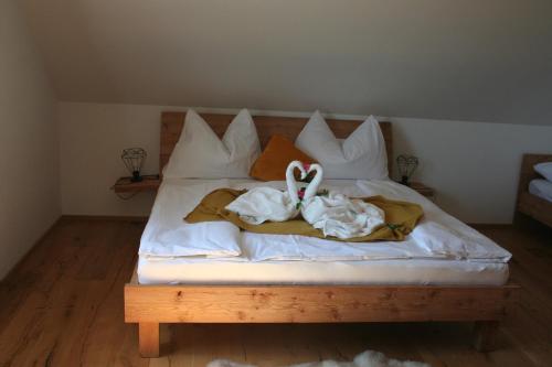 a bed with white sheets and a stuffed animal on it at Rebenchalet in Sankt Anna am Aigen