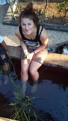 a young girl sitting in a pool of water at Crown Guest House in Ambarawa
