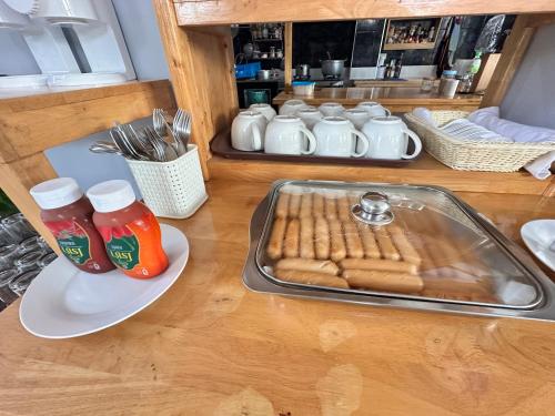 a table with a tray of hot dogs and bottles of ketchup at บ้านชวนชมเกาะล้าน in Ko Sak