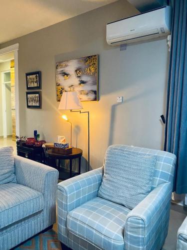a living room with a couch and a chair at Jacomo Residences in Dar es Salaam