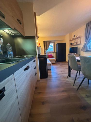 kuchnia ze zlewem i stołem w pokoju w obiekcie Casa Porrone w mieście Passo del Tonale