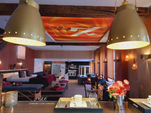 a lobby with couches and tables and two lights at Le BELLEA in Verviers