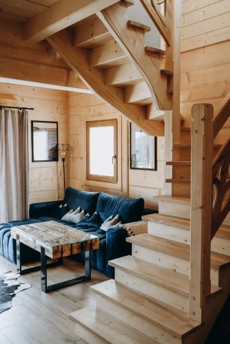 a living room with a couch and a wooden staircase at Przewodnicka Chata in Kościelisko