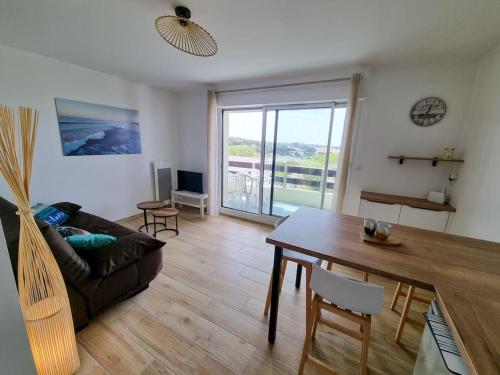 un salon avec un canapé et une table dans l'établissement Les Landais-Appart cosy centre Mimizan plage 4p, à Mimizan-Plage