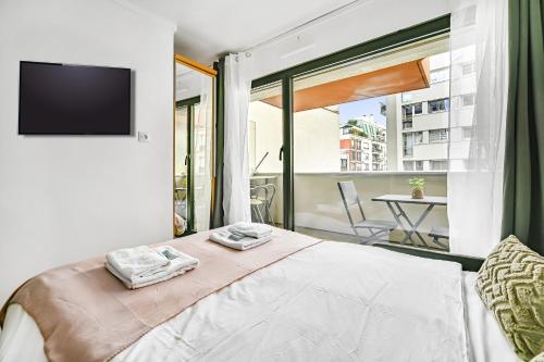 - une chambre avec un lit, une télévision et un balcon dans l'établissement La Felicita - Studio avec Balcon Paris - Netflix, à Paris