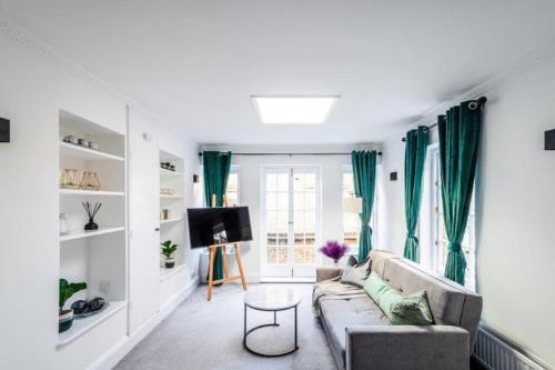a living room with green curtains and a couch at Liverpool street Apartment in London