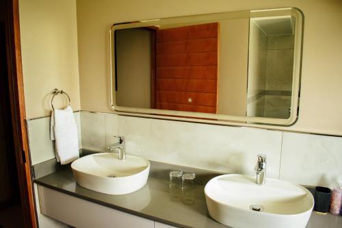 a bathroom with two sinks and a mirror at DUBE SAFARI LODGE at Kruger Park Lodge 505 in Hazyview