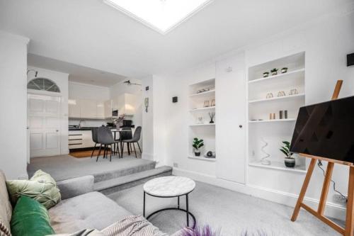 a living room with a couch and a table at Liverpool street Apartment in London