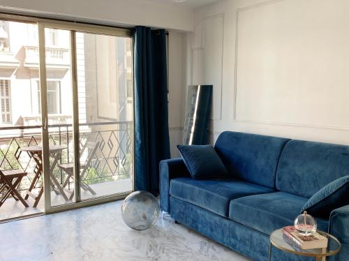 un salon avec un canapé bleu et un balcon dans l'établissement Studio Carré Or - Centre Nice 2m à pied de la mer, à Nice