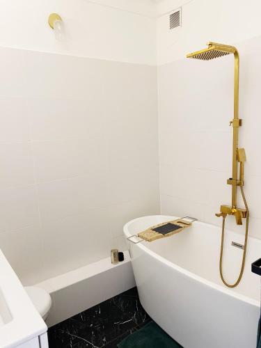 une salle de bain blanche avec une baignoire et une douche dans l'établissement Studio Carré Or - Centre Nice 2m à pied de la mer, à Nice