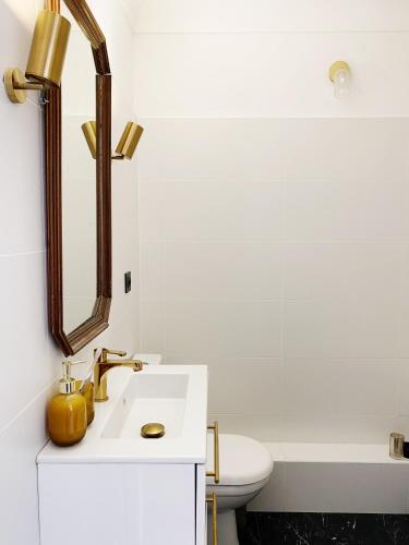 une salle de bain blanche avec un lavabo et un miroir dans l'établissement Studio Carré Or - Centre Nice 2m à pied de la mer, à Nice