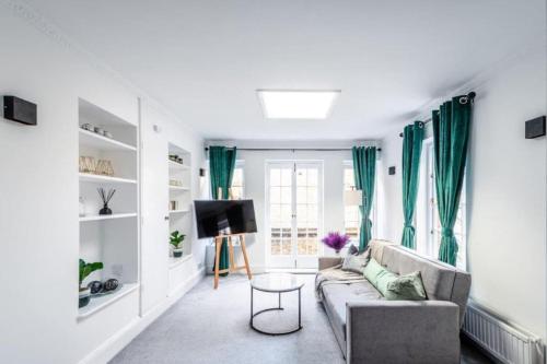 a living room with green curtains and a couch at Liverpool street Apartment in London