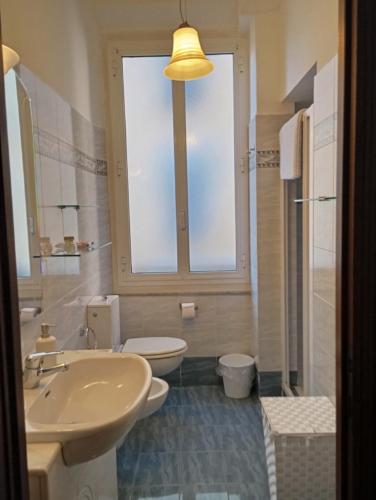 a bathroom with a sink and a toilet and a window at Small Luxury House in La Spezia