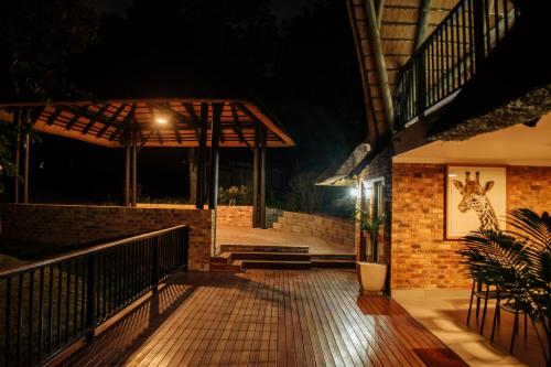 a night view of a porch with a giraffe on the wall at DUBE SAFARI LODGE at Kruger Park Lodge 505 in Hazyview