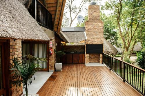 an external view of a house with a wooden deck at DUBE SAFARI LODGE at Kruger Park Lodge 505 in Hazyview
