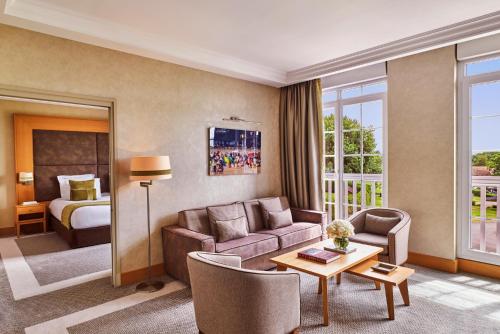 a hotel room with a couch and a bed at Hôtel Barrière L'Hôtel du Golf in Deauville