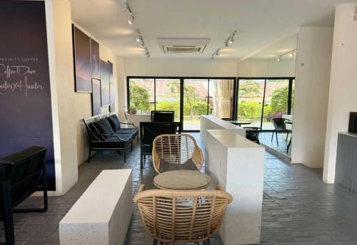 a lobby with wicker chairs and tables in a building at Collection O The Singha Chiangmai Hotel in Chiang Mai