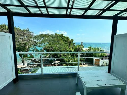 a balcony with a bench and a view of the ocean at บ้านชวนชมเกาะล้าน in Ko Sak