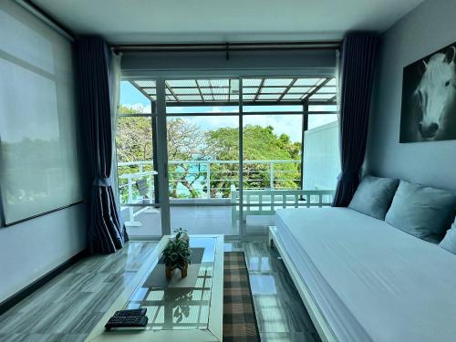 a bedroom with a bed and a glass table at บ้านชวนชมเกาะล้าน in Ko Sak