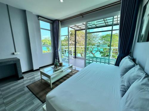 a bedroom with a bed and a large window at บ้านชวนชมเกาะล้าน in Ko Sak