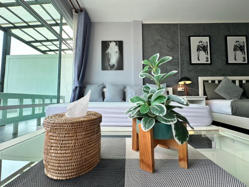 a bedroom with a bed and a potted plant at บ้านชวนชมเกาะล้าน in Ko Sak