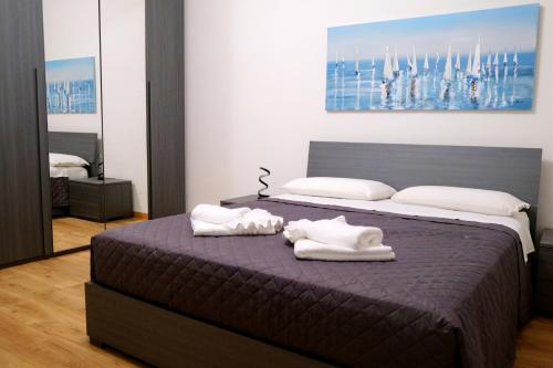 a bedroom with a bed with towels on it at Porto Antico Apartment in Genoa