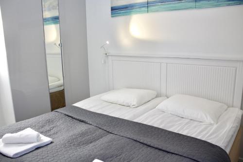 a bed with two white towels on top of it at Modern Slope Apartment in Vuokatti