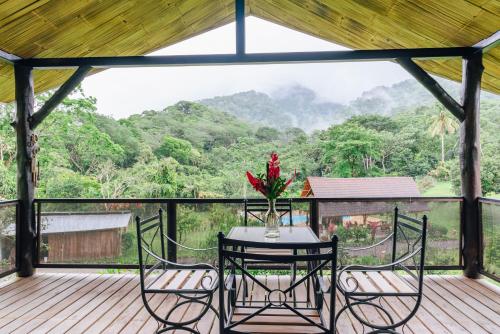 a table and chairs on a deck with a view at Hacienda Mil Bellezas - Private 40ha Jungle Reserve in Quepos