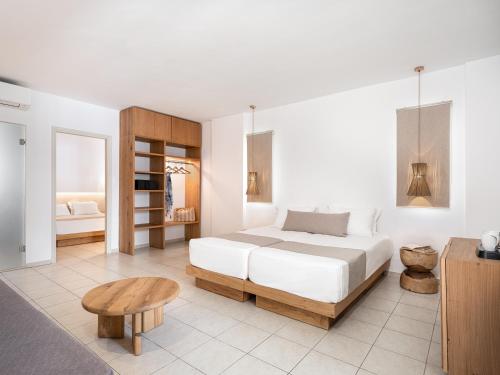 a white bedroom with a bed and a table at Magda Hotel Club in Gouves