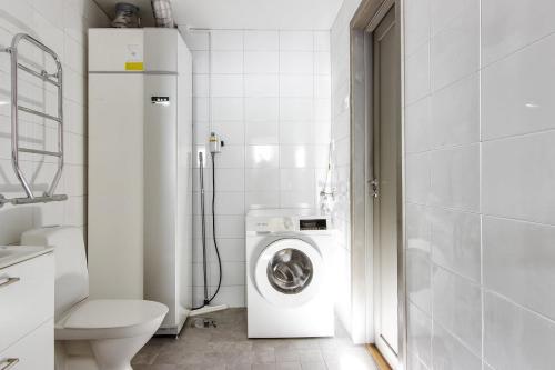 a bathroom with a washing machine and a toilet at Bastuvallen - Ramundberget in Bruksvallarna