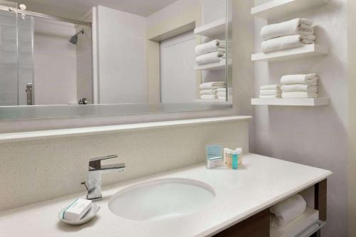 a bathroom with a sink and a mirror and towels at Hampton Inn Denville-Rockaway-Parsippany in Denville