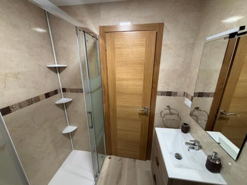 ein Badezimmer mit Dusche, Waschbecken und Spiegel in der Unterkunft Piso en Ribeira a 20metros de la playa de Coroso by Cristian&Tamara "alquileres" in Ribeira