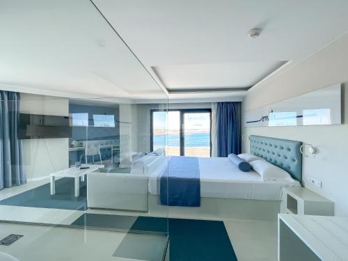 a bedroom with a large bed and a table at Corralejo Surfing Colors Hotel&Apartments in Corralejo