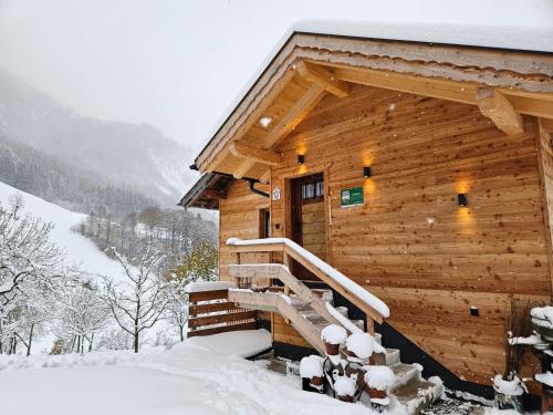 a log cabin with snow on the stairs at Ferienhaus Maria´s Hoamatl in Gallzein