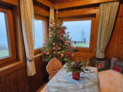 a christmas tree on a table in a room with windows at Ferienhaus Maria´s Hoamatl in Gallzein